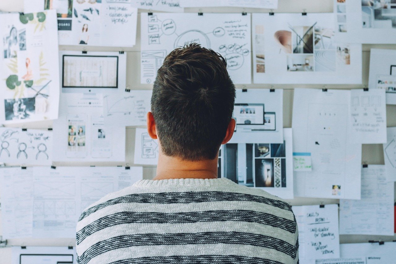 Entrepreneur reviewing business setup plans and Dubai company registration steps, analyzing documents and diagrams related to free zone, mainland, and offshore company formation.